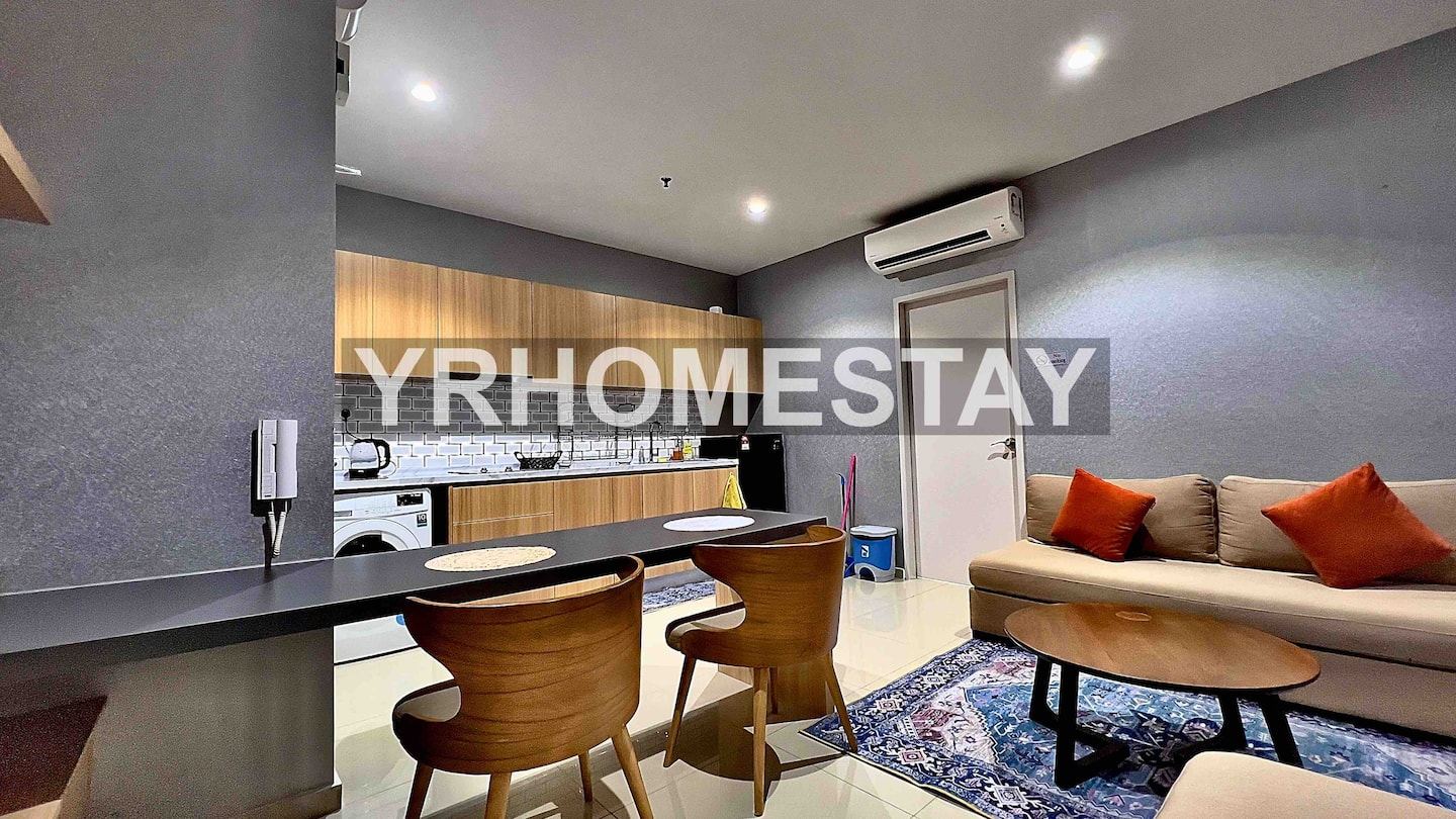 Living and dining area of the Liberty Tower unit against a brick feature wall.